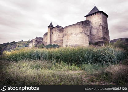 Old stone castle on background of cloudy sky. Old stone castle