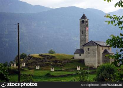 Old stone church with Swiss flag in Ticino canton, Switzerland