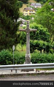 Old stone cross on the road in Switzerland