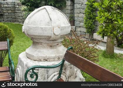 Old stone element and bench in back yard house garden