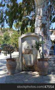 Old stone fountain in the campaign on the Cretan