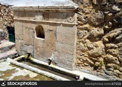 Old stone fountain in the campaign on the Cretan