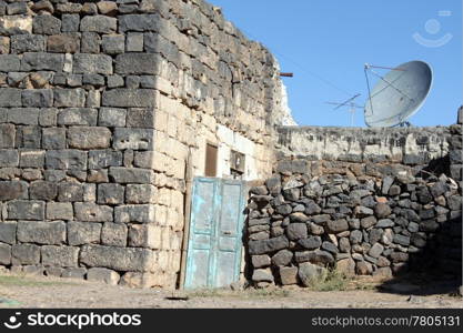 Old stone house with TV antenna in Old Bosra, Syria