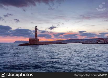Old stone lighthouse in the Venetian harbor at dawn. Chania. Crete.. Lighthouse in Chania. Greece.