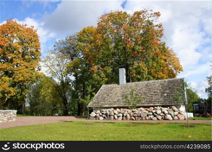 Old stone shed on a background of trees