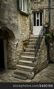 old stone stairs in front of a house in croatia, with plants at the door