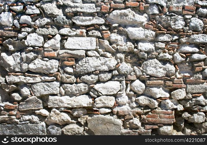 Old stone wall of varios materiales (stone,brick,tile) in Madrid (Spain)