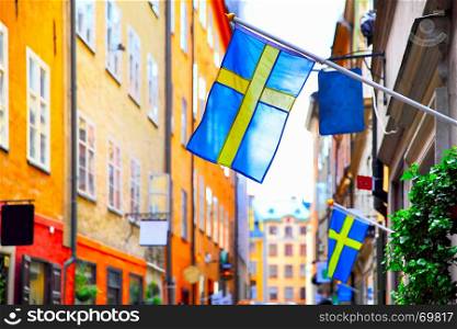 Old street in Stockholm with swedish flags, Sweden. Shallow DOF, focus on the first flag