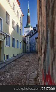 Old street in Tallinn Estonia showing cobbled road and the old church