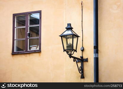 old street lamp and a window on a yellow wall