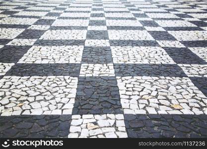 Old street road paved surface stone pavement walkway texture pattern Chess board. Granite cobblestones pavement background. Abstract background of old cobblestone pavement vintage style Europe.