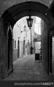 Old street with archway in San Marino - Black and white cityscape