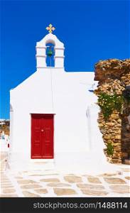 Old street with white ancient greek church in Mykonos town (Chora), Greece