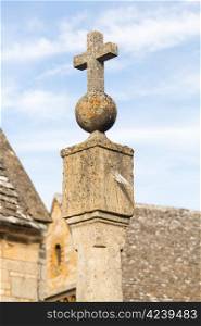 Old sun dial topped with orb and cross in Cotswolds town of Stanton