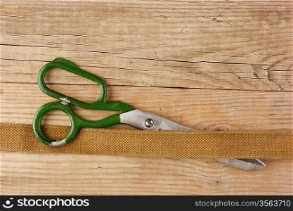 old tailor scissors and belt on the wooden background