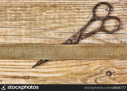 old tailor scissors and belt on the wooden background