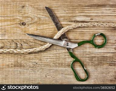 old tailor scissors and rope on the wooden background