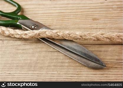 old tailor scissors and rope on the wooden background