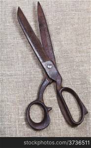 old tailor scissors on textile background