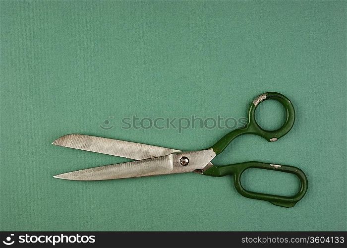 old tailor scissors on the green background