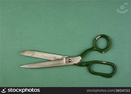 old tailor scissors on the green background