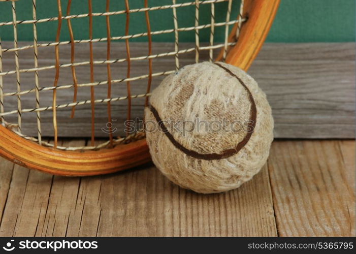 old tennis ball and racket on a wooden floor