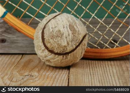 old tennis ball and racket on a wooden floor