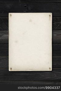 Old textured paper sheet nailed on a black wood table. vertical Mockup. Old textured paper sheet nailed on a black wood table