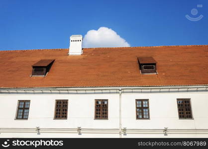 Old tiled roof with two attic windows and chimney in old part of Minsk, Belarus