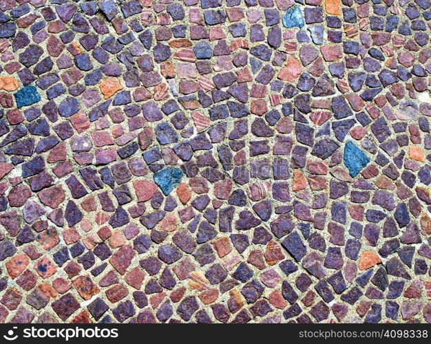 Old tiles inlaid into cement on the ground.