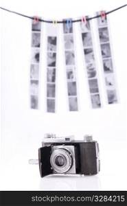 Old-time rusty photo-camera and film strips on white background