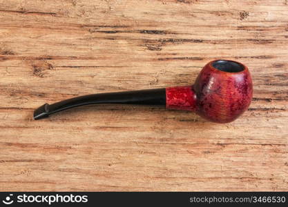 old tobacco pipe on a wooden background