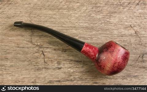 old tobacco pipe on a wooden background