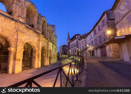 Old town and roman Arles Amphitheatre during evening blue hour, Arles, Provence, southern France. Arles Amphitheatre, France