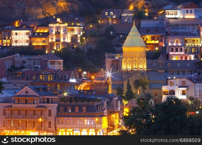 Old Town at night, Tbilisi, Georgia.. Amazing View of Saint George Church, famous colorful houses and balconies in Old Town in night Illumination during evening blue hour, Tbilisi, Georgia