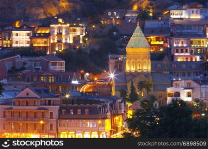 Old Town at night, Tbilisi, Georgia.. Amazing View of Saint George Church, famous colorful houses and balconies in Old Town in night Illumination during evening blue hour, Tbilisi, Georgia