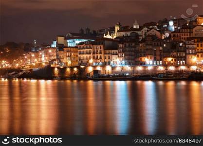 Old town of Porto at night, Portugal.. Ribeira and Old town of Porto with mirror reflections in the Douro River at night, Portugal, Portugal.
