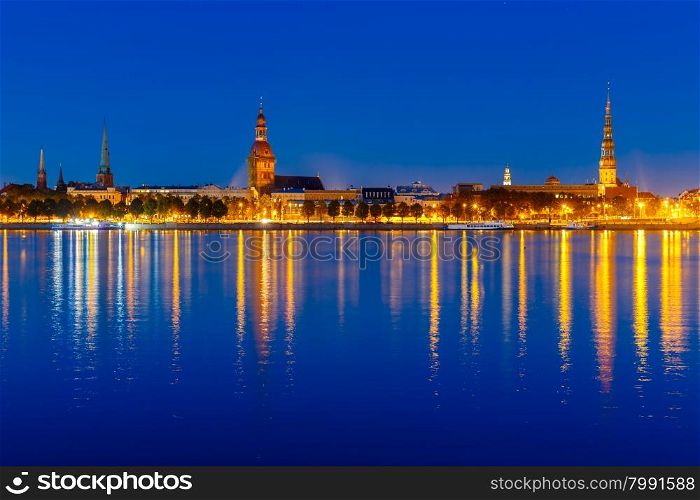 Old Town of Riga and River Daugava at night, Riga Cathedral and Saint Peter church in the background, Latvia