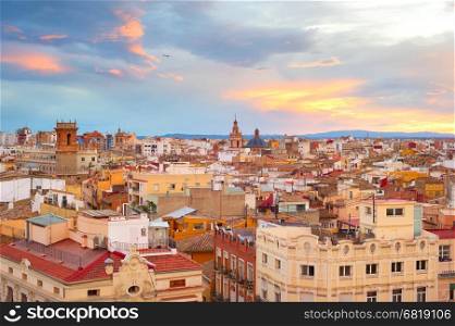 Old Town of Valencia at sunset. Plane flying in the sky. Spain