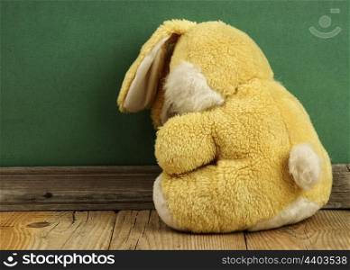 Old toy bunny on a wooden floor