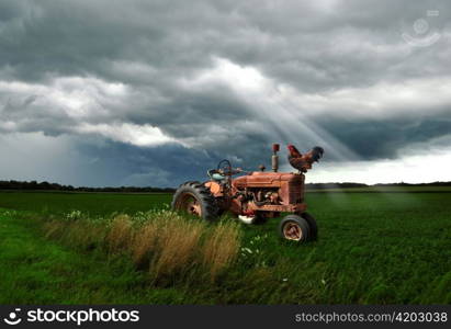 old tractor on a summer field in a stormy weather