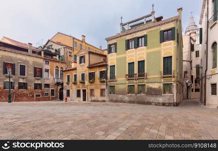 Old traditional medieval houses in a small square in the old town. Venice. Italy.. Old beautiful houses in a traditional small square in Venice.