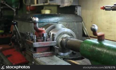 Old turning machinery working in craftsmanship and making metal parts.