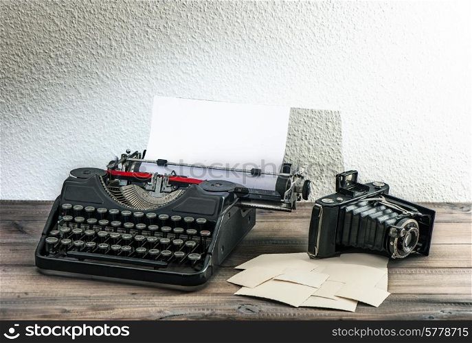 old typewriter and vintage photo camera on wooden background. antique objects. collectibles