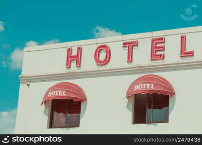 Old unclean hotel facade with vintage neon sign retro color stylized