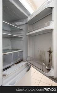 Old used dirty refrigerator with mold,aged junk in the kitchen. Old used dirty refrigerator with mold,aged junk