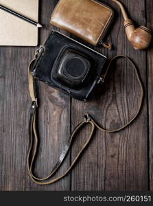 old vintage camera in a case on a wooden background, top view