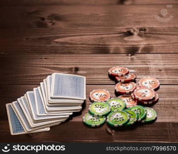 old vintage cards and a gambling chip on a wood table.