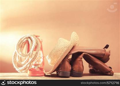 Old vintage cowboy tools - leather footwear, stetson, rope and kerosene lamp