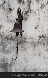 Old vintage metal bell on the wall